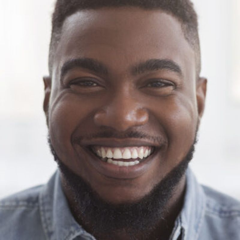 Smiling man with a beard in casual shirt.