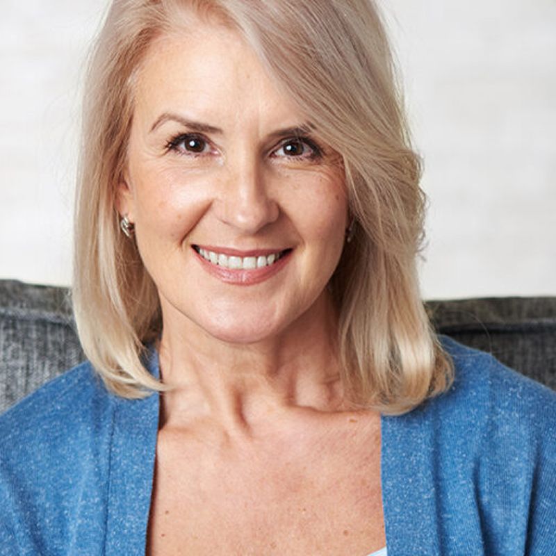 Smiling woman with blonde hair and blue sweater.