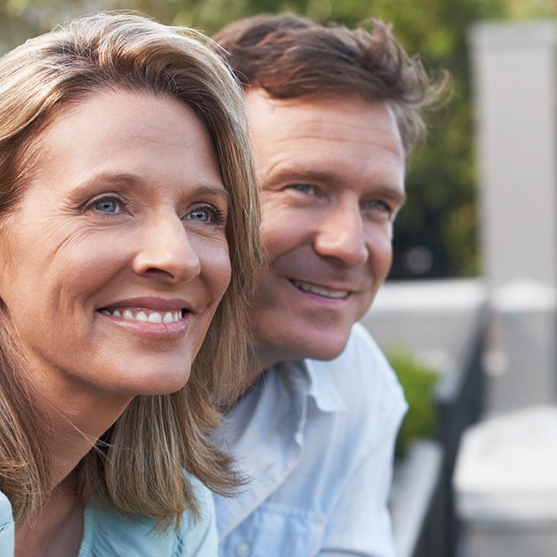 Smiling older man in a garden setting.