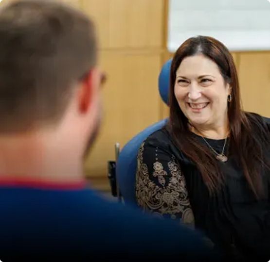 Woman smiling during conversation with man.