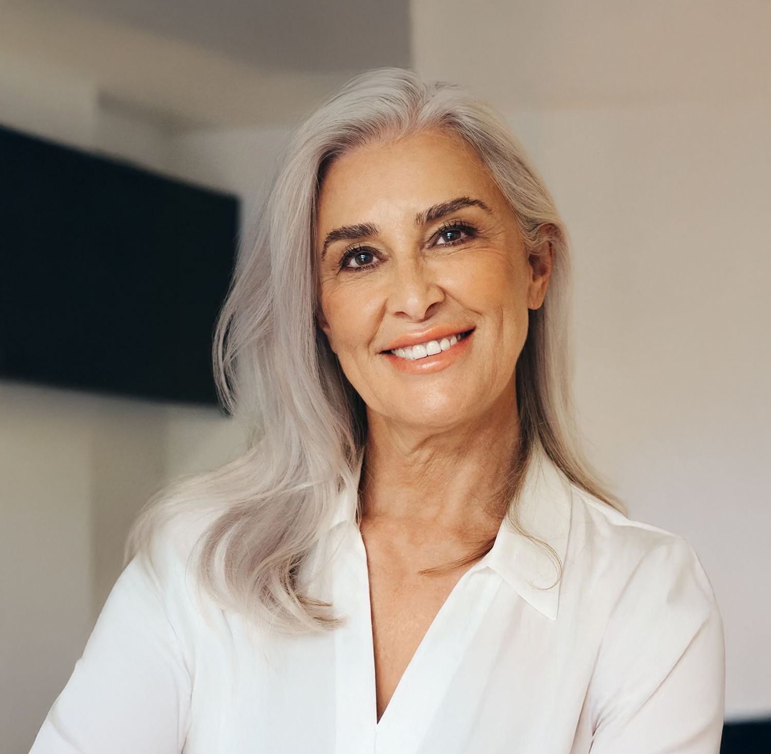 Smiling woman with long silver hair.
