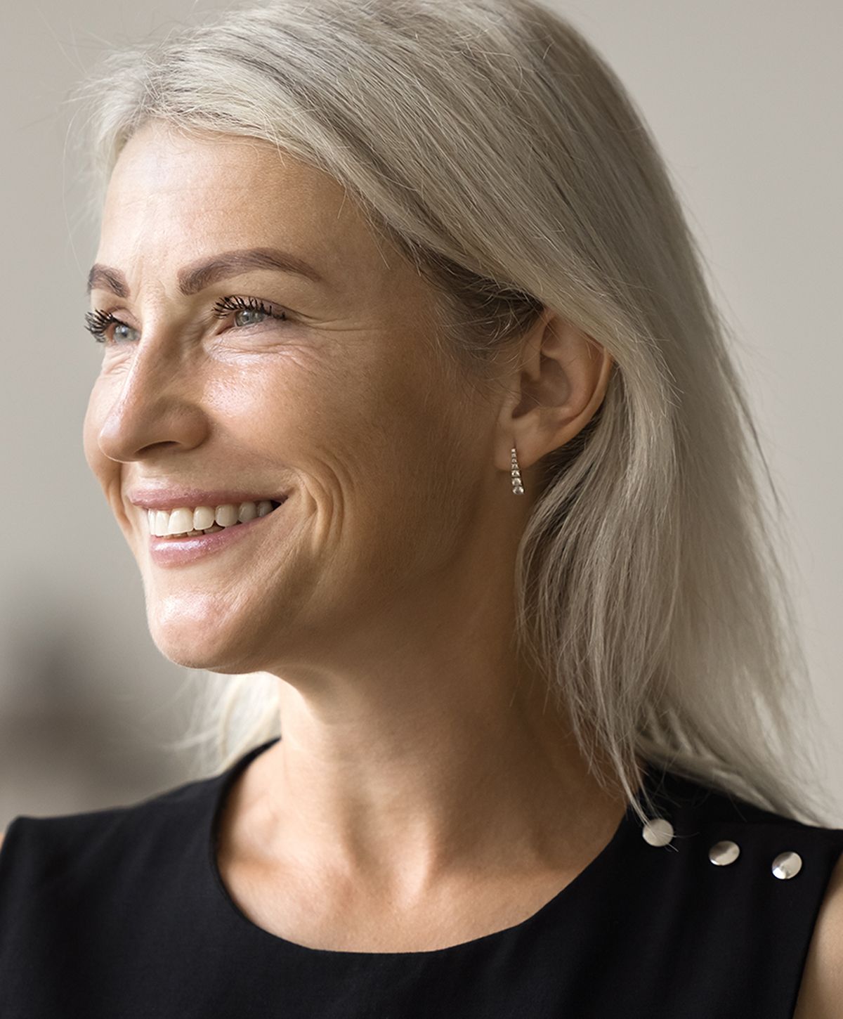 Smiling woman with long, light hair and earrings.