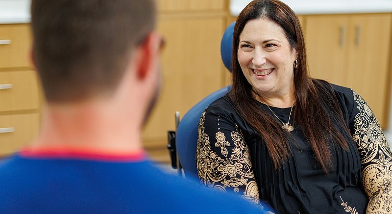 Patient smiling during consultation with healthcare provider.