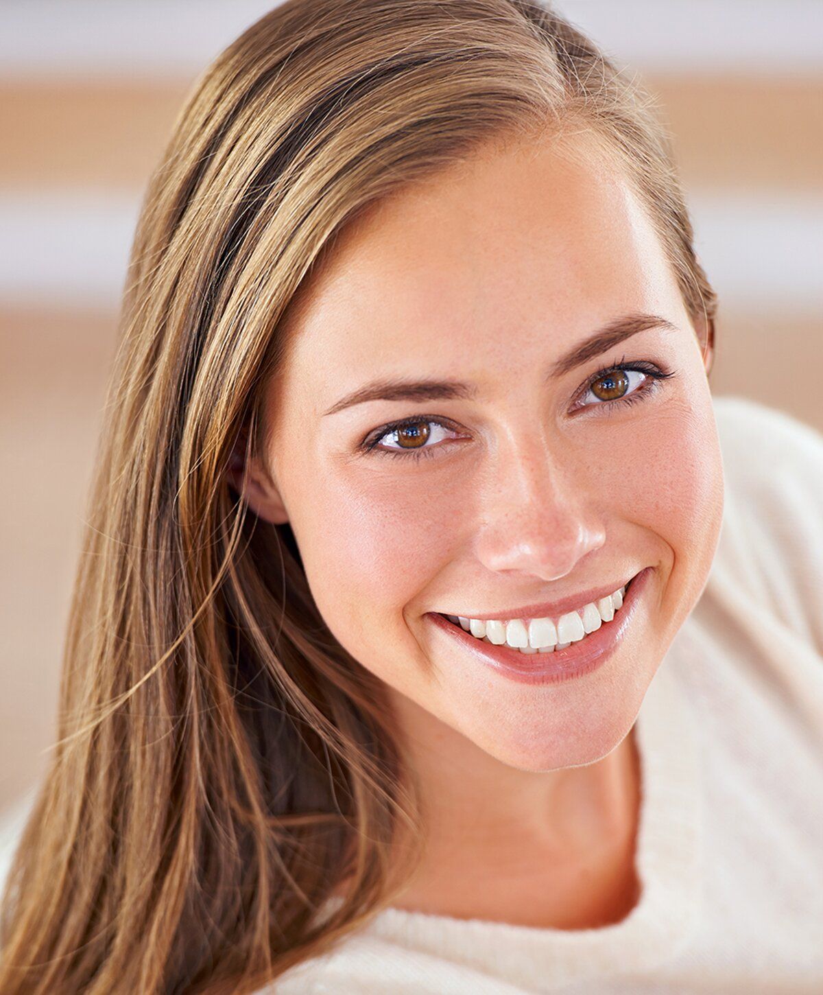 Smiling woman with long hair in casual sweater.