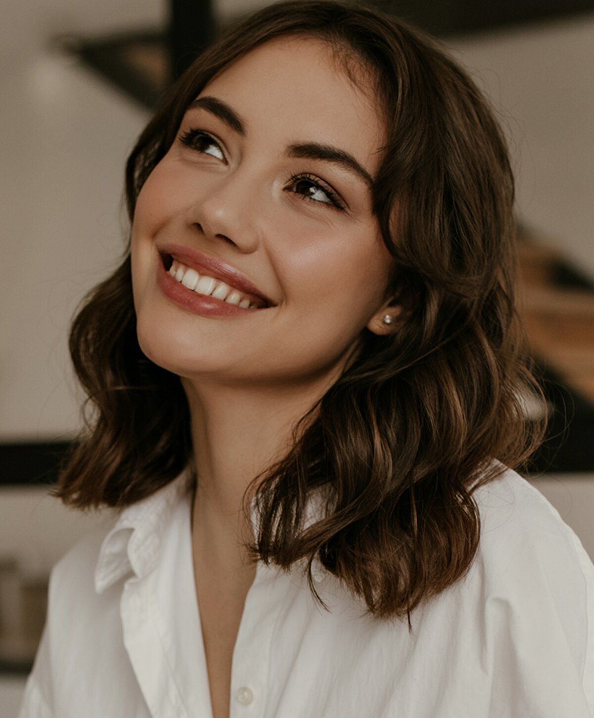 Smiling woman in casual white shirt outdoors.