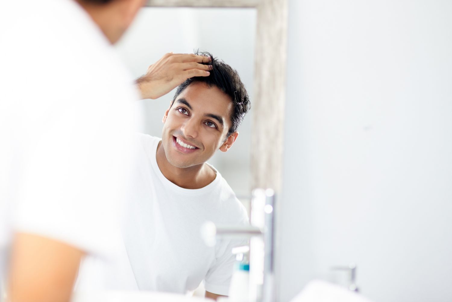 Man checking out teeth in front of mirror.