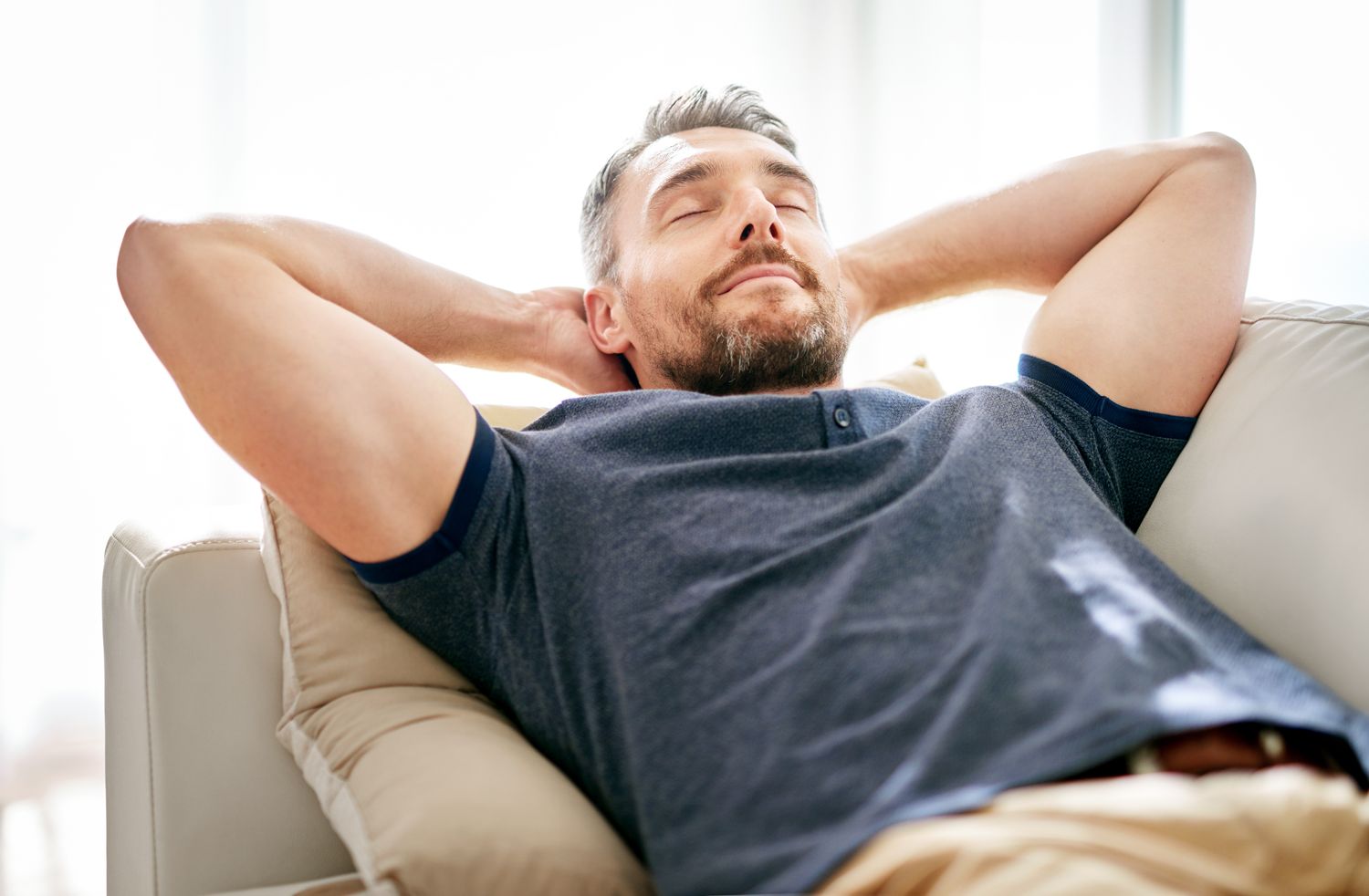 Man relaxing on couch with eyes closed.