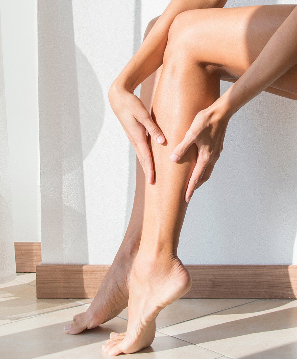 Woman gently caressing her bare legs.