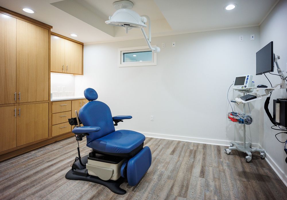 Modern medical examination room with blue chair.