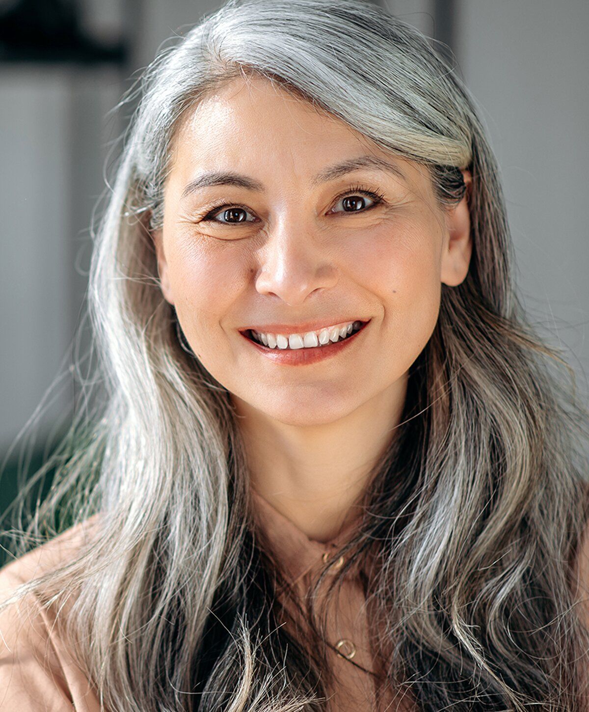 Smiling woman with long gray hair.
