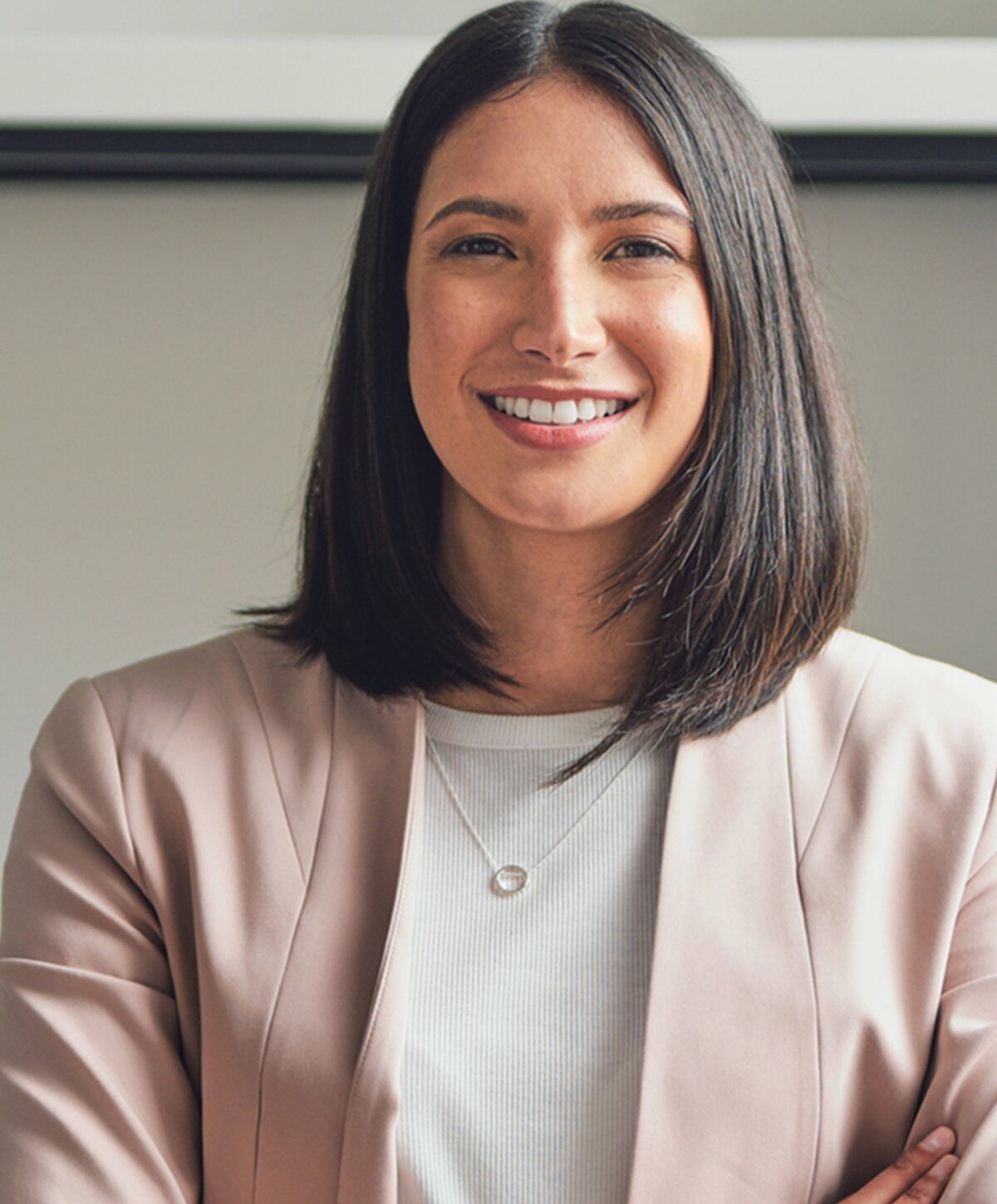 Smiling woman in a light blazer portrait.