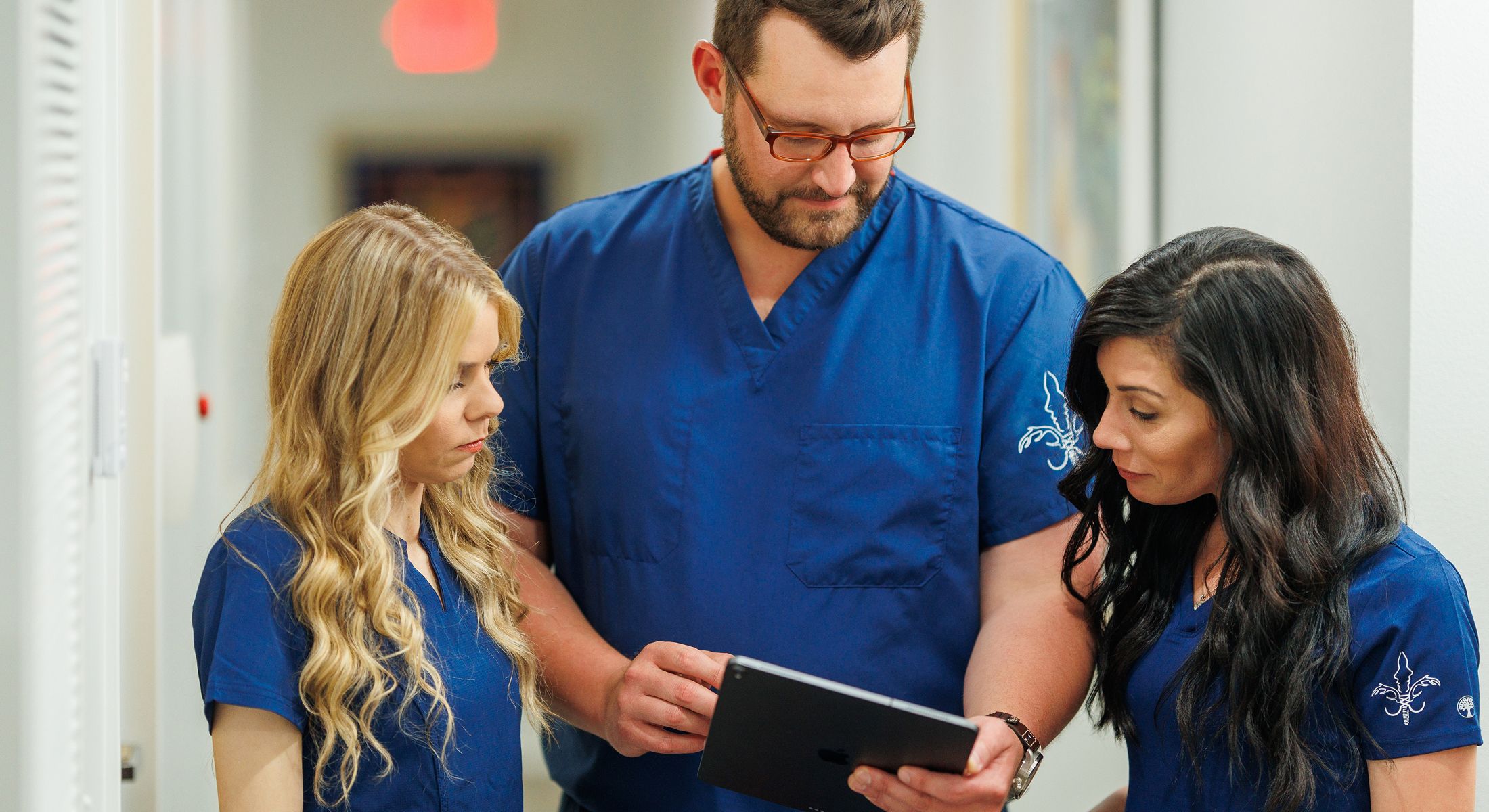 Medical team discussing information on tablet.