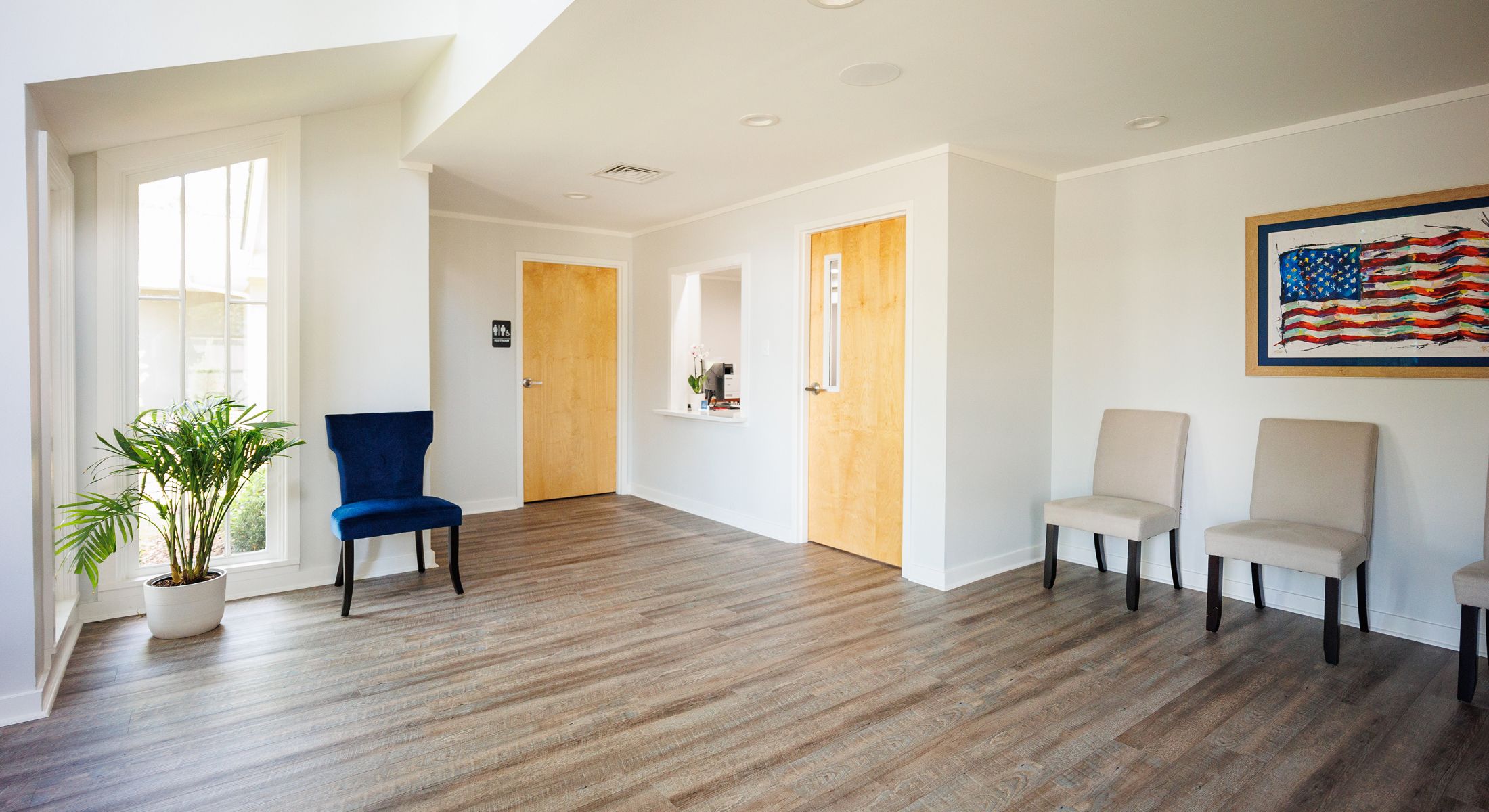 Modern waiting room with chairs and plants.