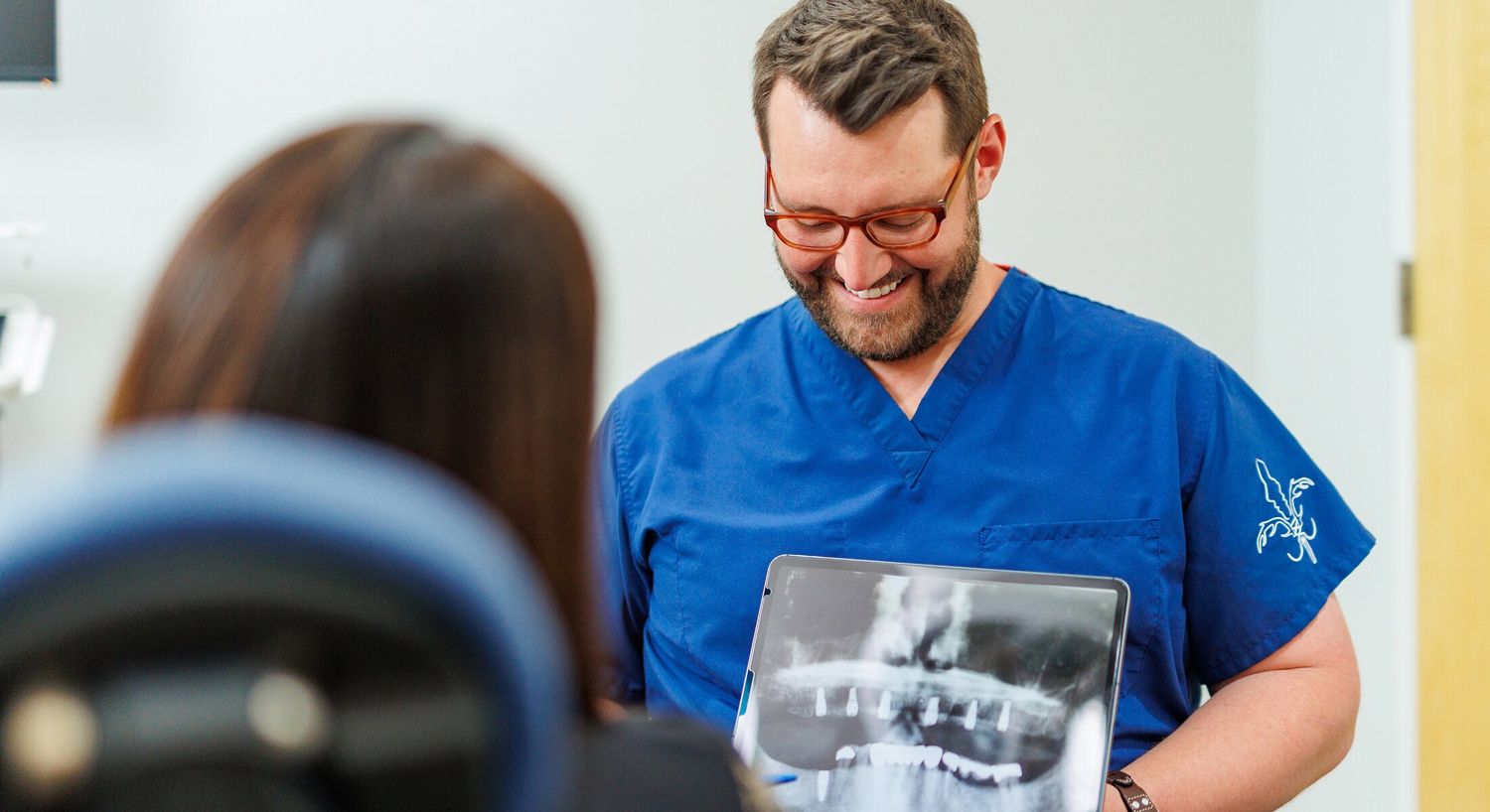Dentist showing x-ray to patient in clinic.