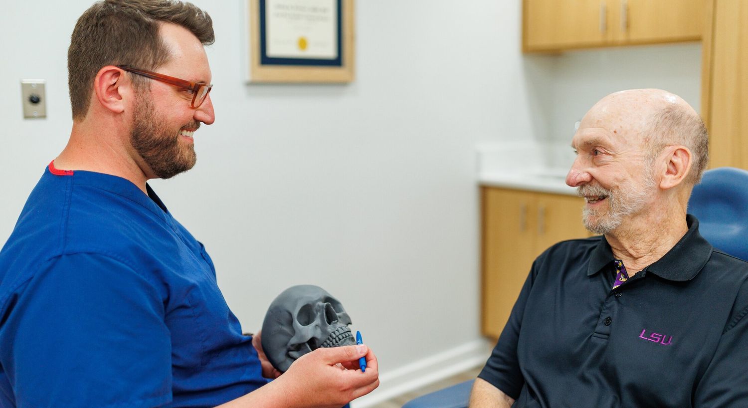 Medical professional discussing skull model with patient.