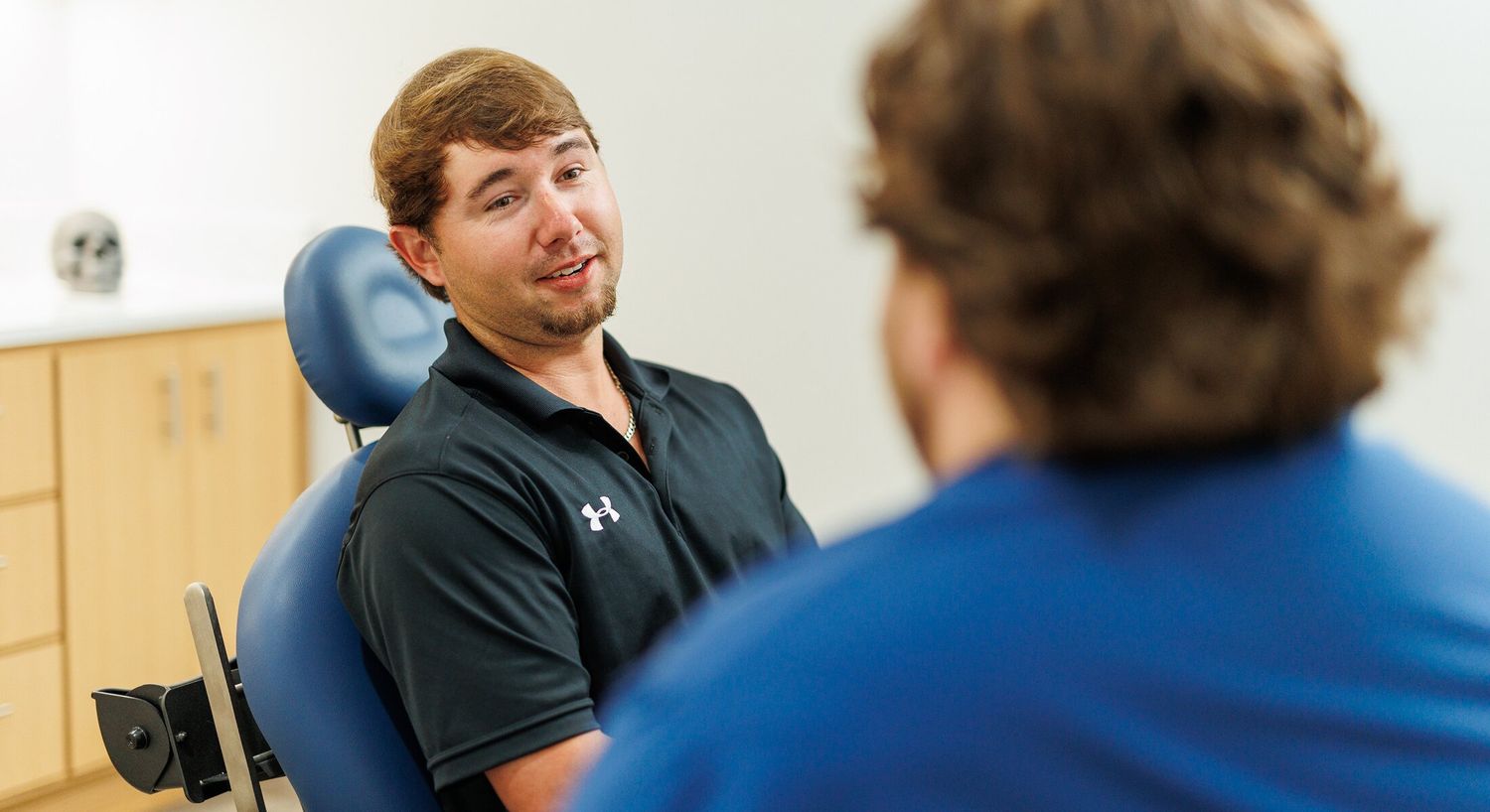 Man speaking with patient in dental office.