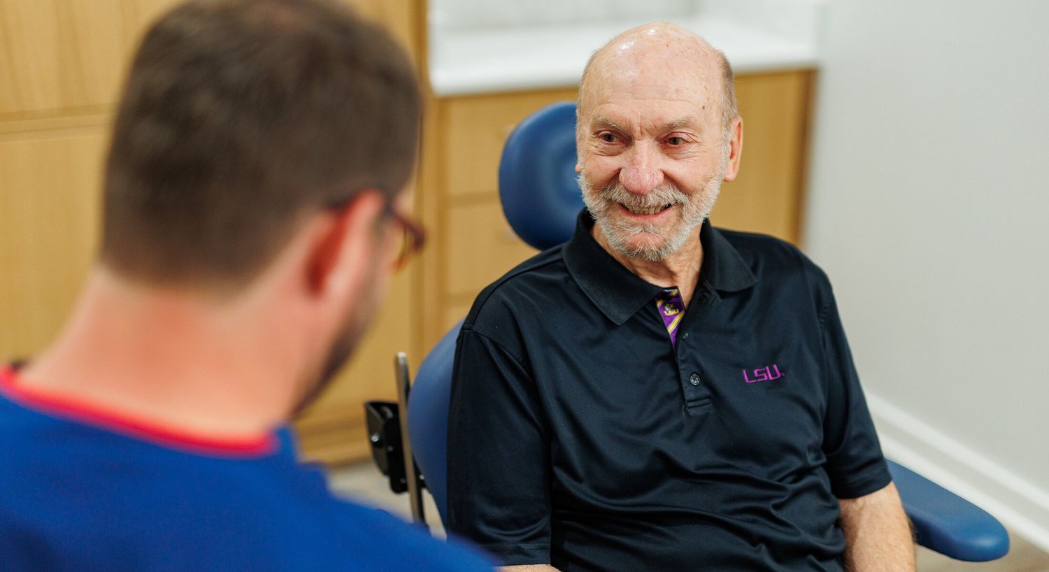 Smiling man interacting with oral surgeon.