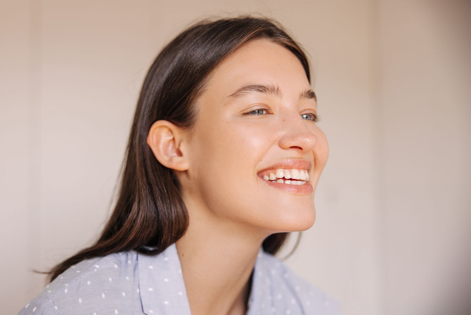 Smiling older woman with light hair, indoor setting.